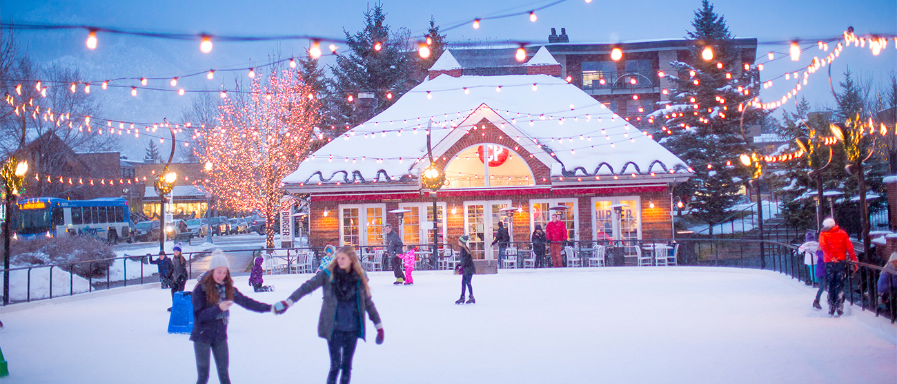Seven people Ice Skating Silver Circle Ice Rink in the town of Aspen, Colorado during winter