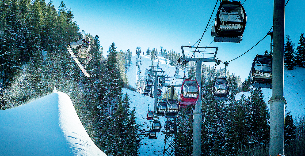 Man going off jump on Aspen Mountain next to gondola in Aspen, Colorado