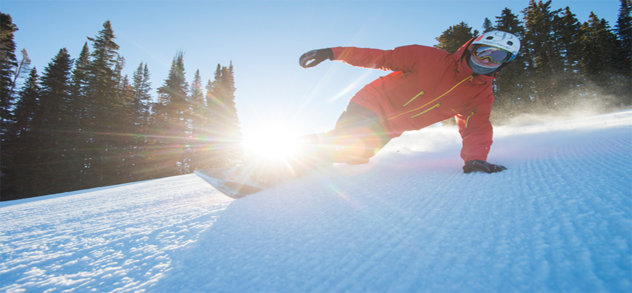 Man Snowboarding down Aspen Mountain in Aspen, Colorado