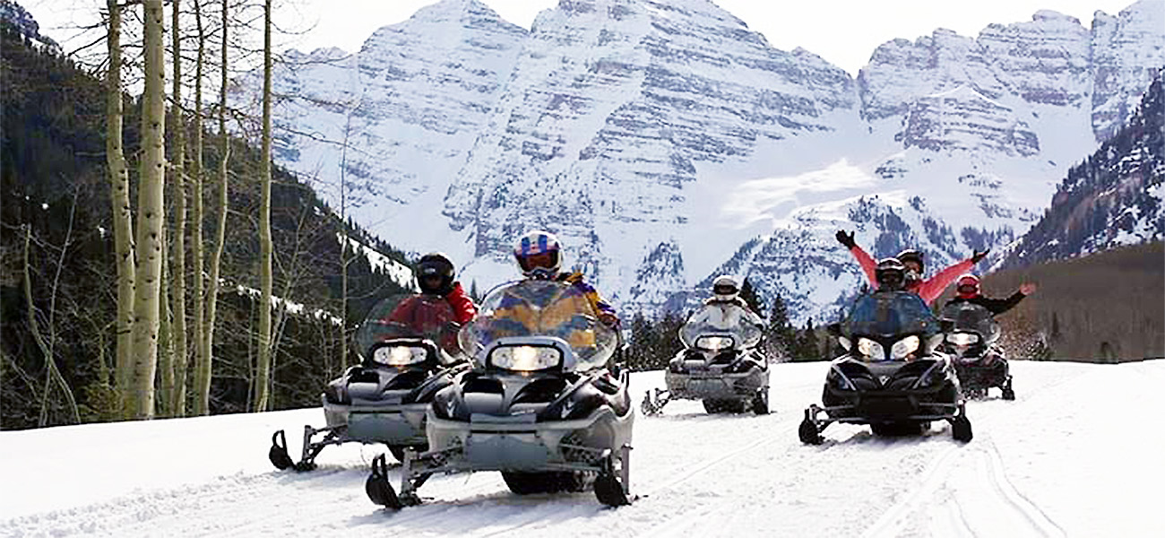 Snowmobile Group of riders Snowmobiling coming back from Maroon Bells in Aspen, Colorado