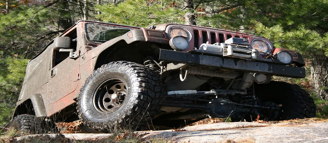old Jeep climbing up rocky trail in forest in Aspen, Colorado