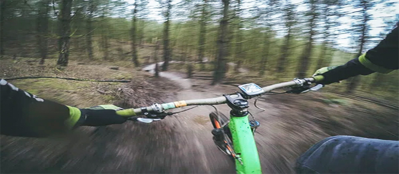 Mountain biking going down trail at high speed