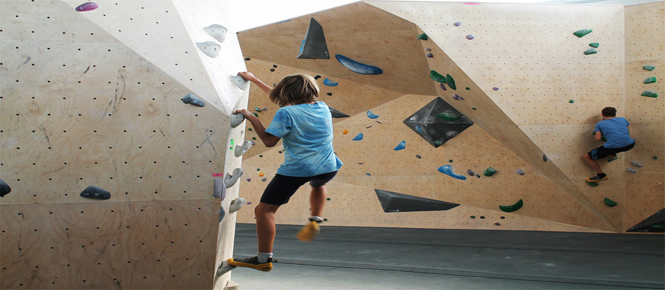 Young boy and man climbing indoors